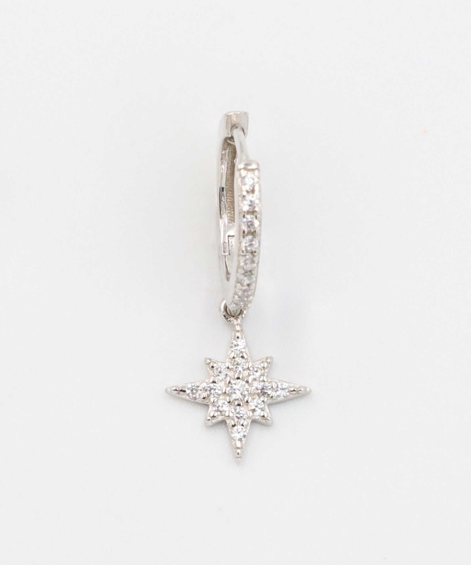 A single "Nova Silver" earring made from sterling silver, featuring cubic zirconia stones arranged in a star-shaped pendant with pave detailing on the hoop.