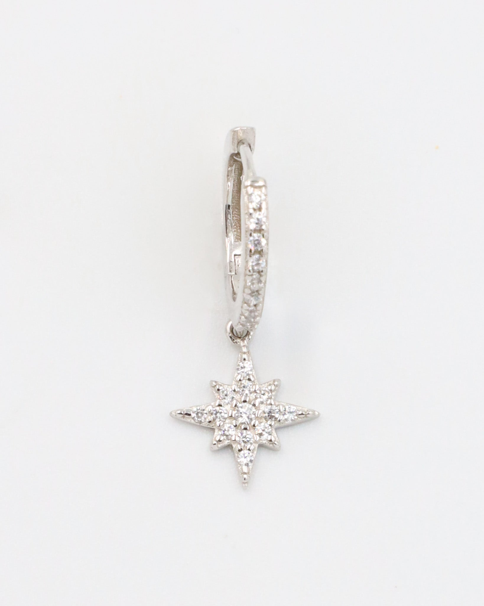 A single "Nova Silver" earring made from sterling silver, featuring cubic zirconia stones arranged in a star-shaped pendant with pave detailing on the hoop.