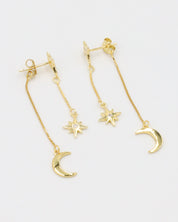 Pair of Reese gold-plated earrings featuring a crescent moon and star with a delicate chain, made from sterling silver.