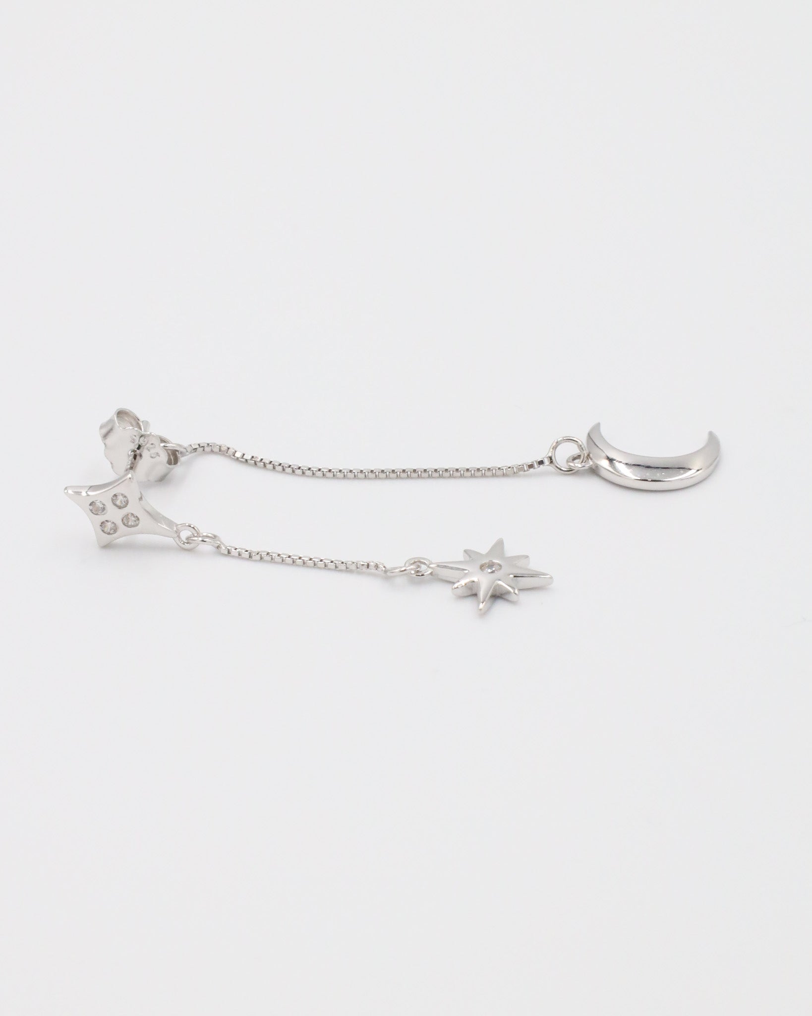 Single Reese silver earring with a crescent moon charm, hanging from a fine chain in sterling silver.