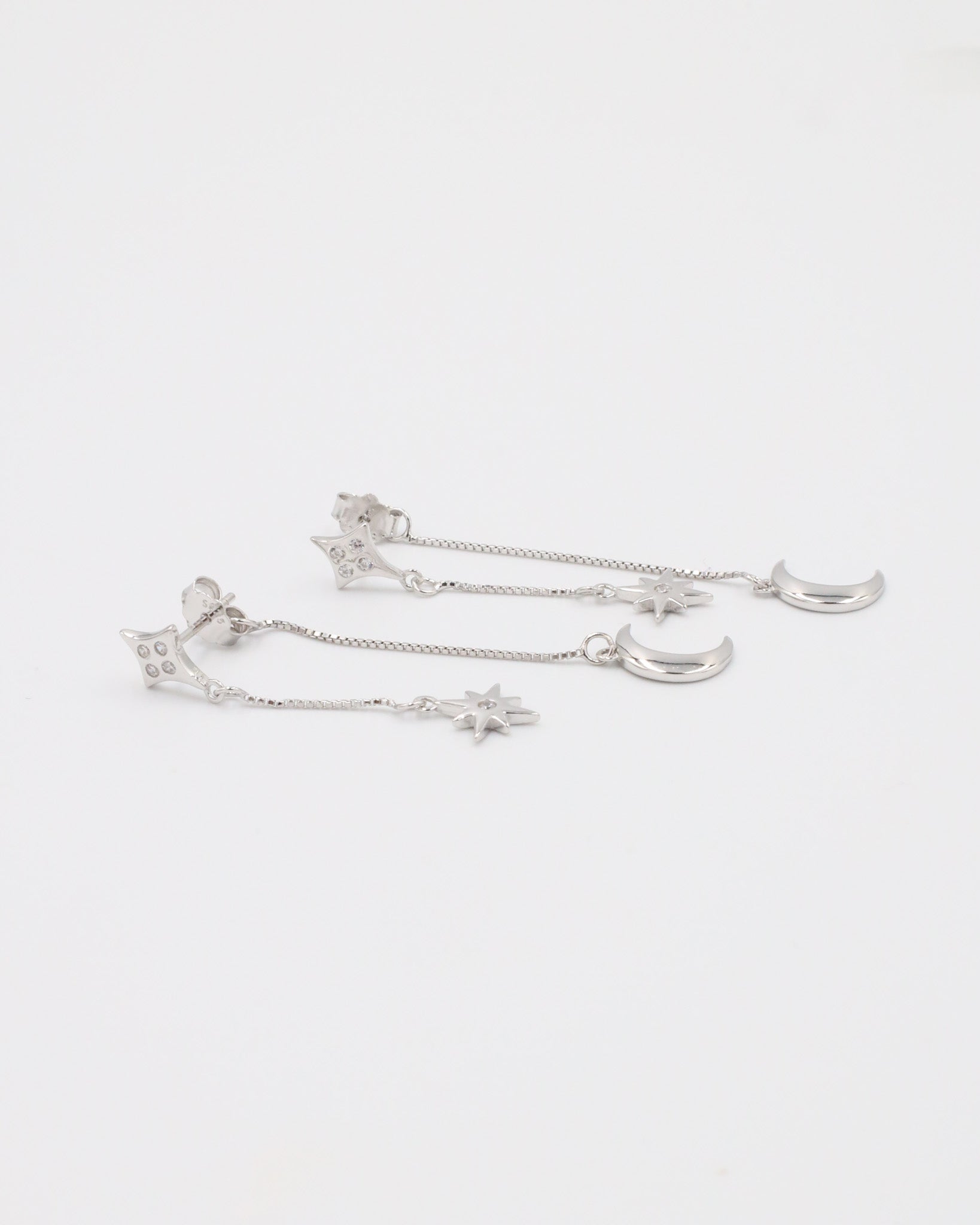 Sterling silver earrings featuring delicate moon and star charms with zirconia detailing, perfect for adding a celestial touch.