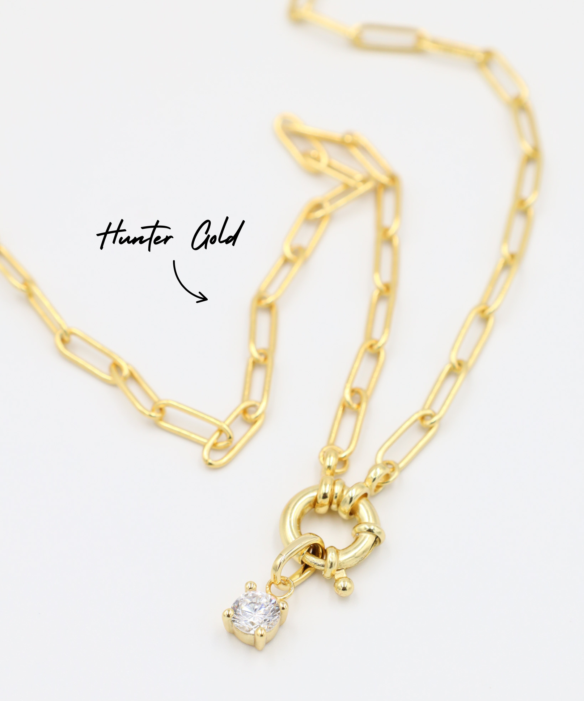 Riley Gold Pendant with zirconia stone, styled with a gold chain necklace.