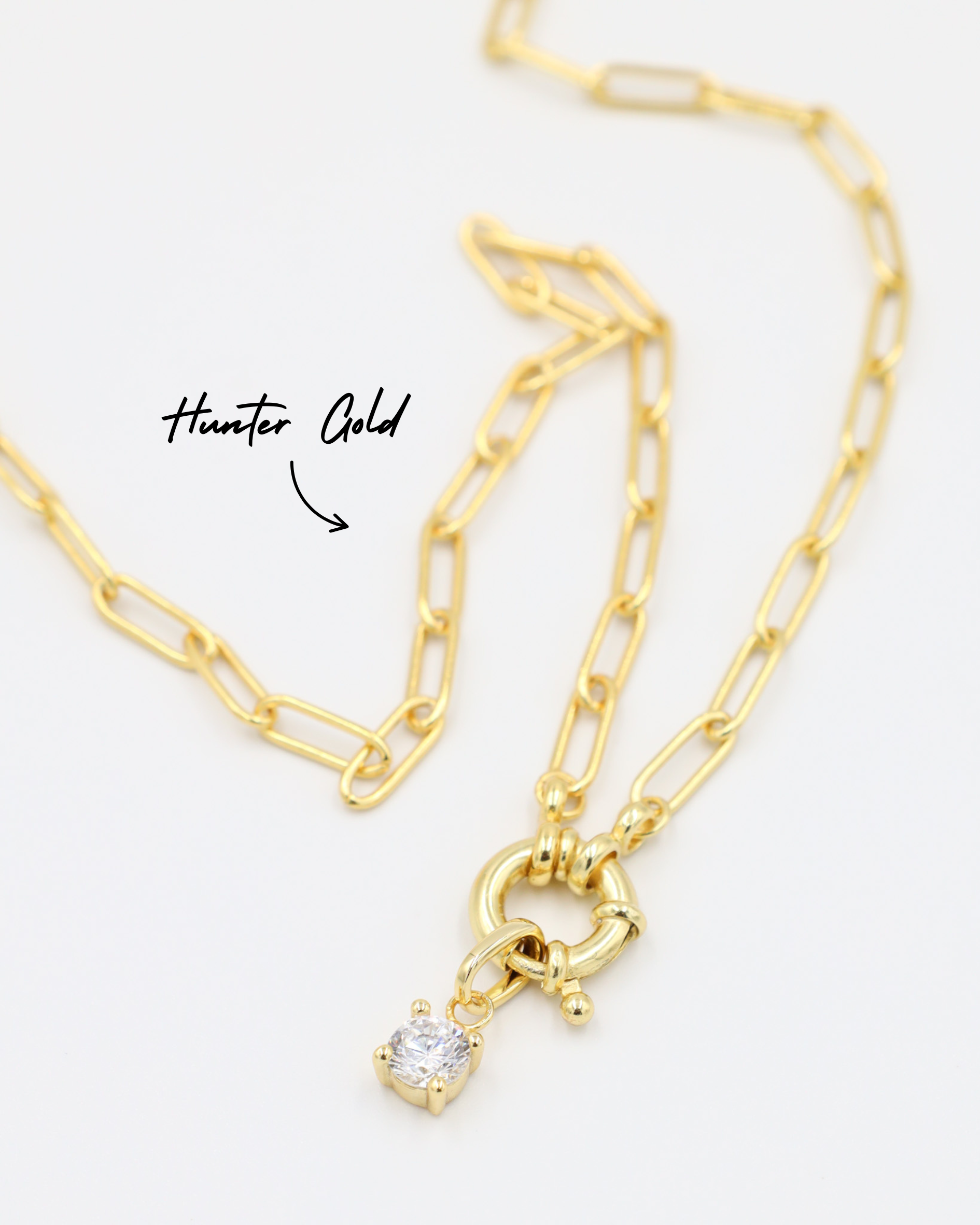 Riley Gold Pendant with zirconia stone, styled with a gold chain necklace.