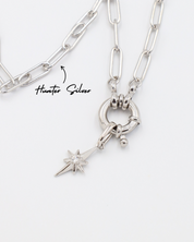 Rhodium plated 925 sterling silver star pendant with zirconia stone displayed on a silver necklace with a toggle clasp.