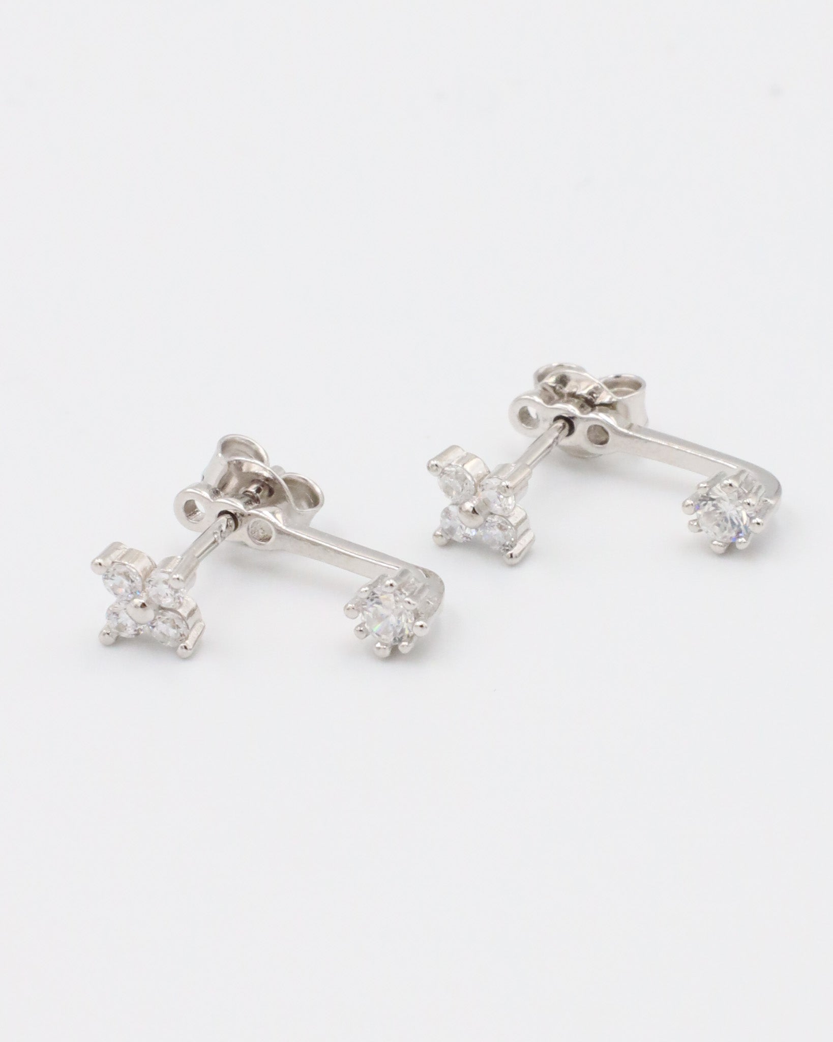 Pair of sterling silver stud earrings featuring zirconia stones in a delicate double stud design.