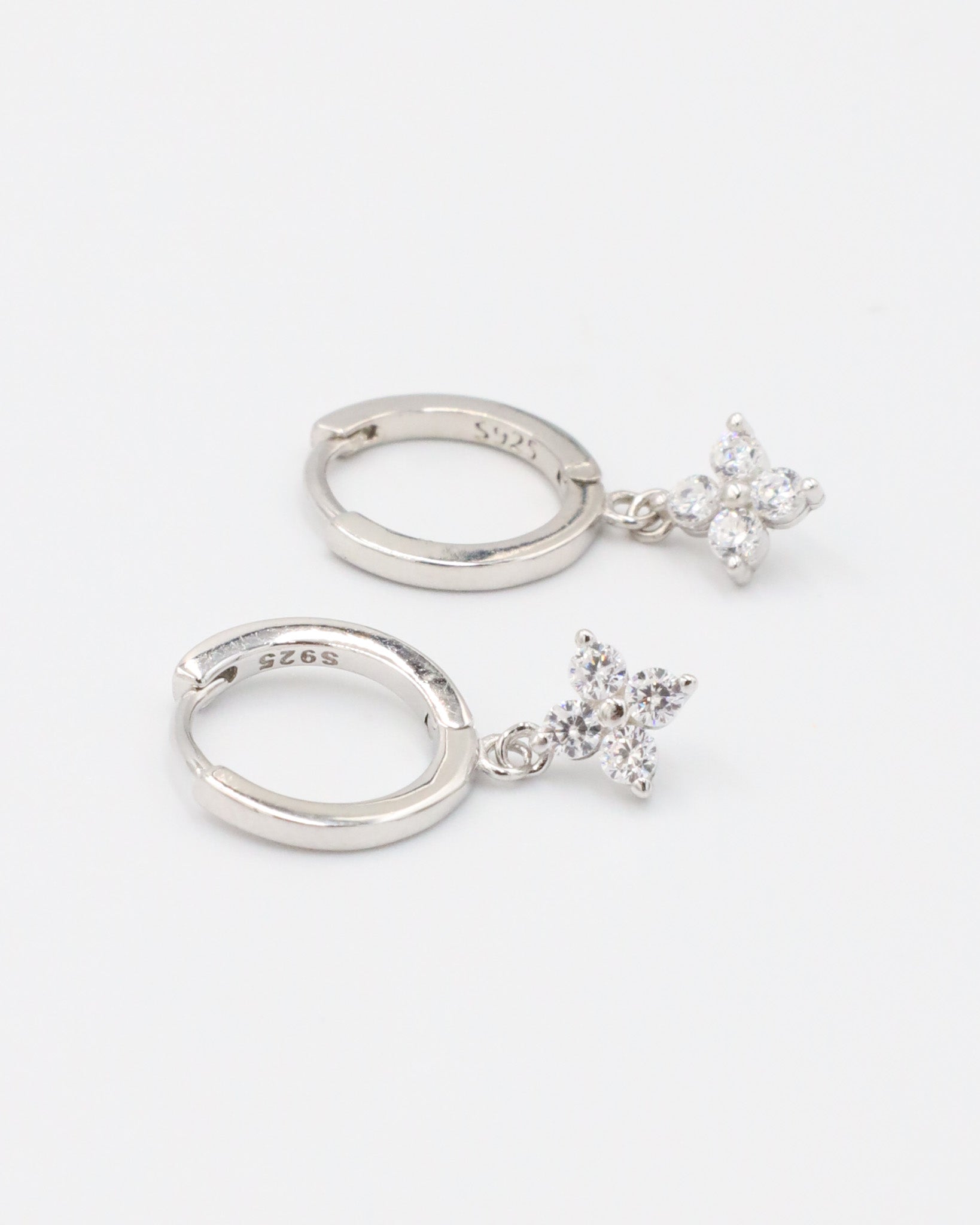 Pair of "Marcy" sterling silver hoop earrings featuring delicate zirconia crystals in a star-like design, made of 925 sterling silver.