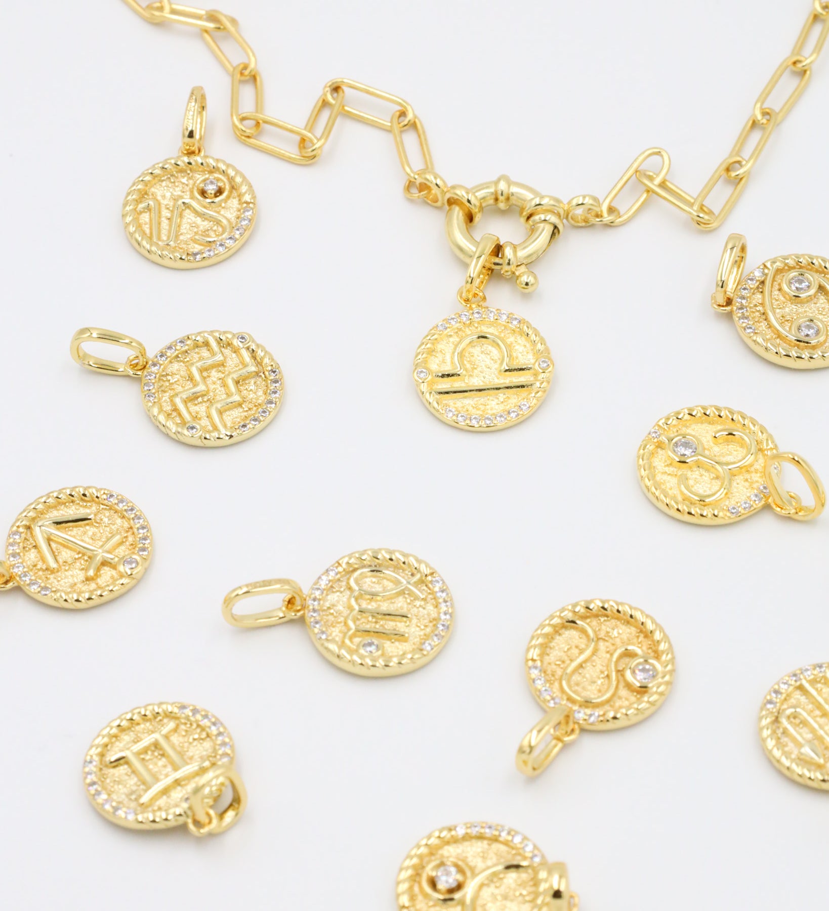 Gold-plated sterling silver zodiac pendants with sparkling zirconia stones arranged with a matching gold chain for a mix-and-match styling option.