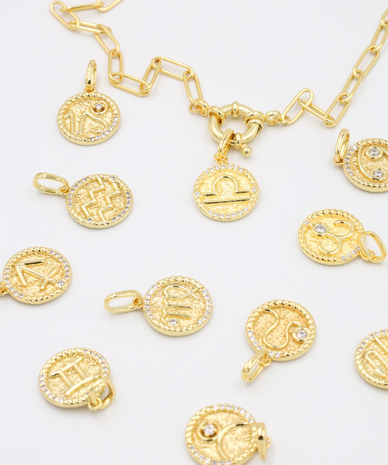 Gold-plated sterling silver zodiac pendants with sparkling zirconia stones arranged with a matching gold chain for a mix-and-match styling option.